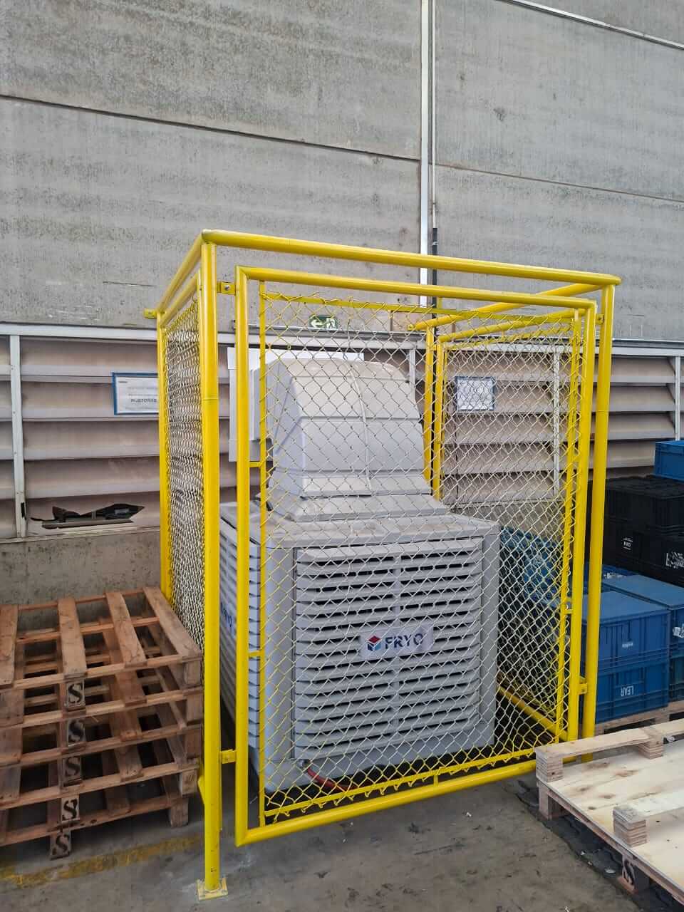 Climatizador industrial Fryo com proteção de grade amarela para ambientes comerciais.