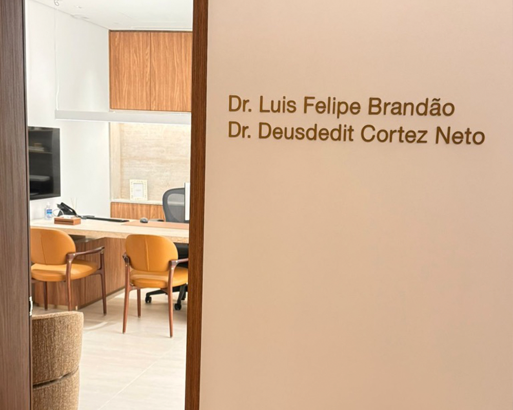 Imagem de ambiente clínico com nomes de médicos na parede.